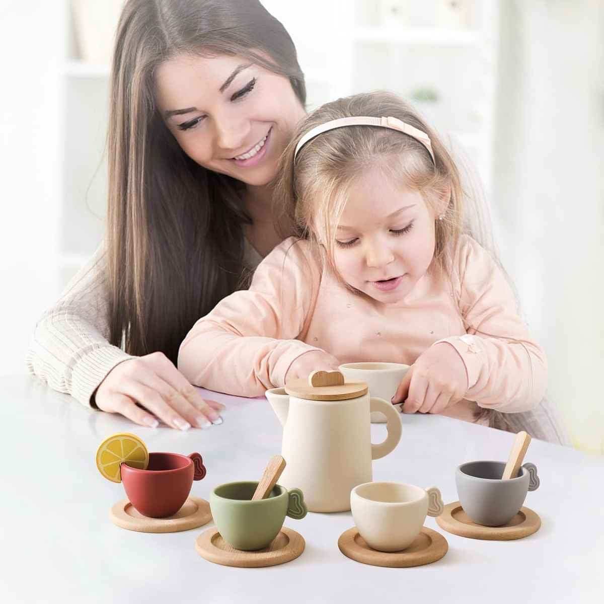 Toddler sitting on parent's lap pretending to serve tea with Montessori tea set 