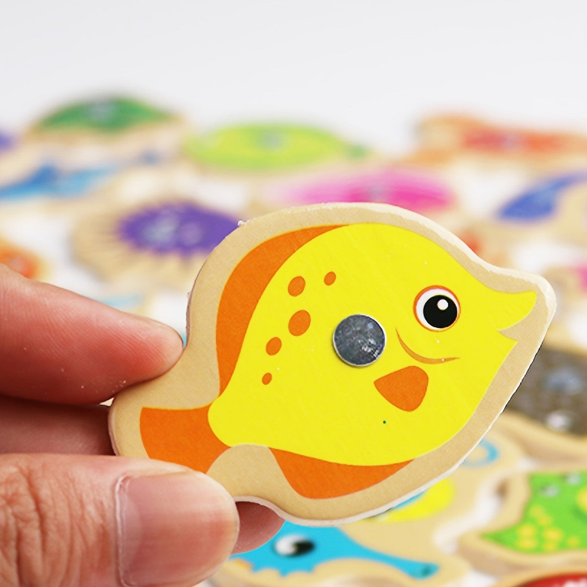 Close-up of wooden magnetic fish for toddler fine motor play